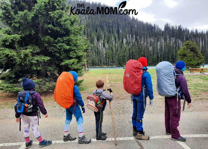 Five kids standing at the Lightning Lakes Parking lot with their hiking backpacks on.