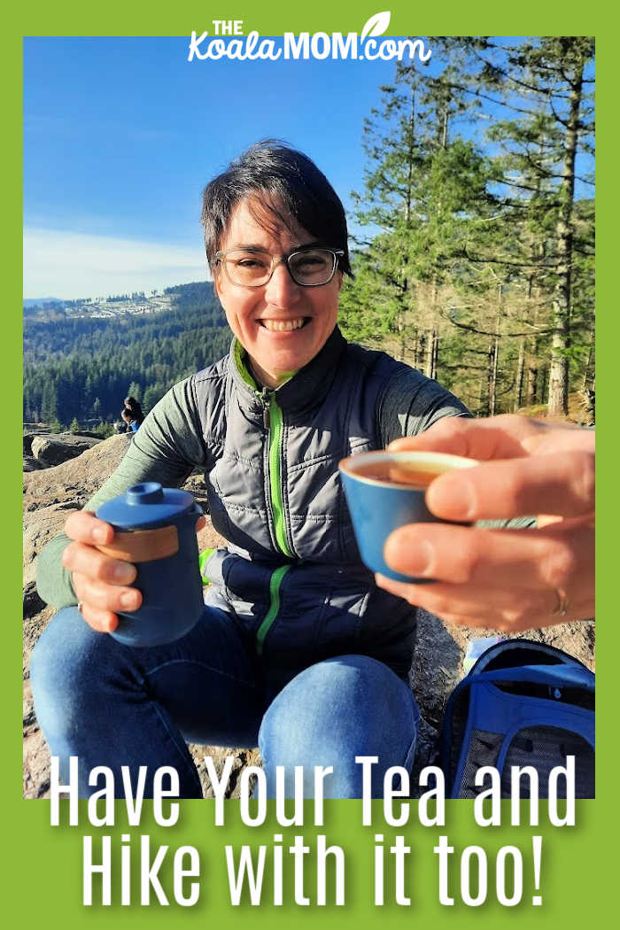Have Your Tea and Hike with it too! Bonnie holds out a tea cup from her Umi Tea Set while sitting on a sunny mountain viewpoint. Photo by Bonnie Way.